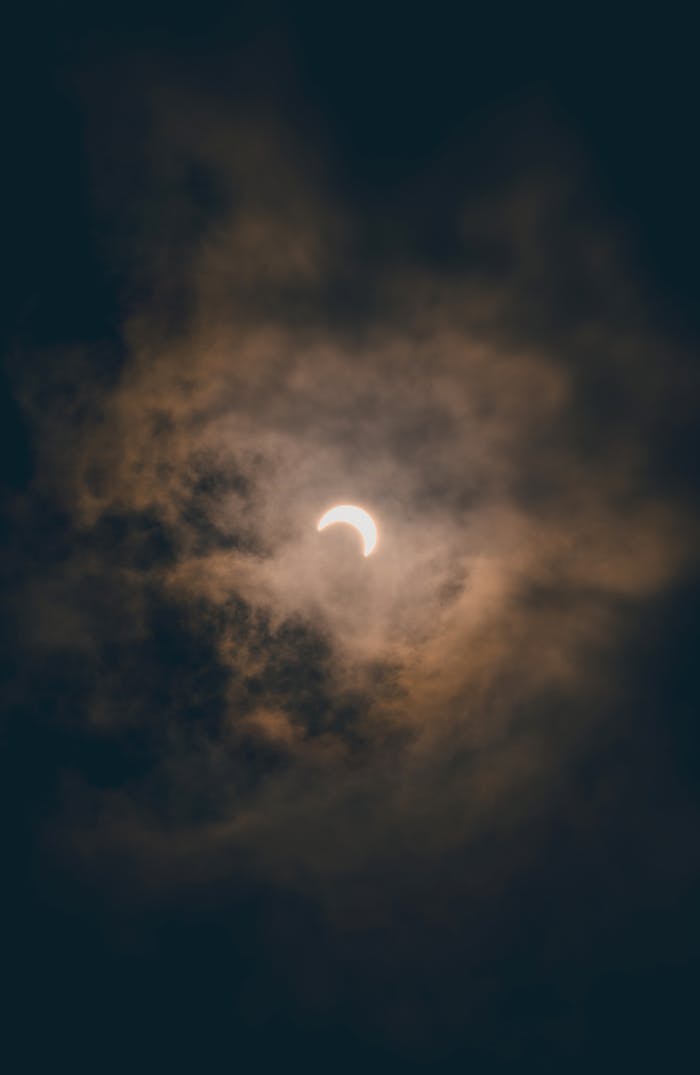 A moody solar eclipse captured over Akumal, Quintana Roo, clouds adding dramatic effect.